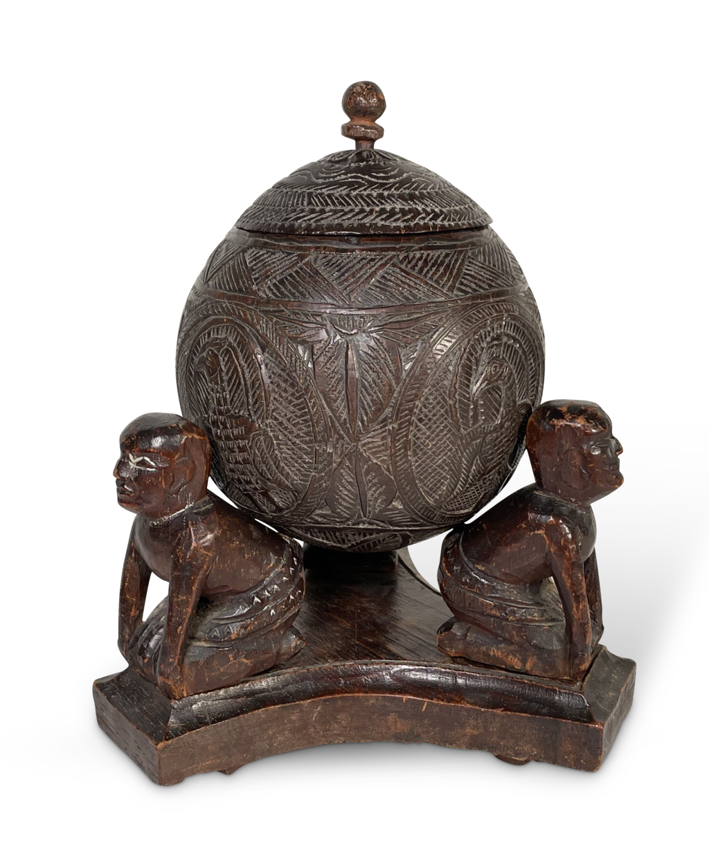 Carved Coconut with Lid Supported on a Stand fitted with Three Carved Kneeling Tribal Figures